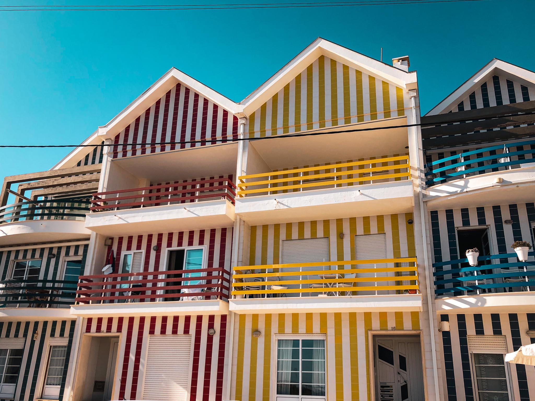 Farbenfrohe Fassaden in Portugal, deren mediterrane Leichtigkeit sich in unseren zeitlosen Kollektionen widerspiegelt