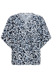 Bluse mit Muster und V - Ausschnitt in schwarz oder weiss - Blossom Hair & Fashion