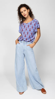 Luftige Sommerbluse mit Federprint und Rückendetail - Blossom Hair & Fashion